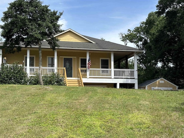 view of front of property featuring covered porch, a front lawn, and roof with shingles