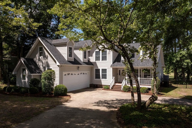 new england style home with driveway, covered porch, a garage, and roof with shingles