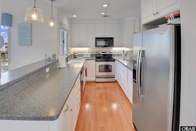 1143 Albemarle Ct Unit 681, Corolla, NC 27927 - kitchen with appliances with stainless steel finishes, white cabinetry, light wood-style floors, a peninsula, and recessed lighting