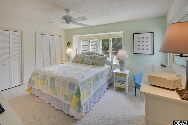 1143 Albemarle Ct Unit 681, Corolla, NC 27927 - bedroom featuring light carpet, two closets, a textured ceiling, and ceiling fan