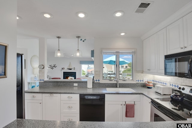 1143 Albemarle Ct Unit 681, Corolla, NC 27927 - kitchen featuring black appliances, white cabinetry, pendant lighting, recessed lighting, and a warm lit fireplace