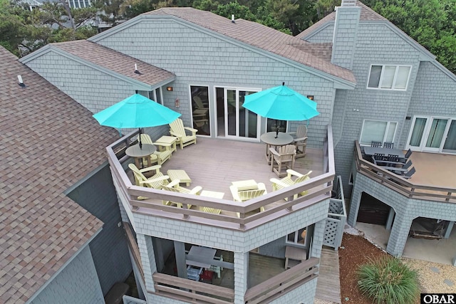 1143 Albemarle Ct Unit 681, Corolla, NC 27927 - rear view of property featuring outdoor dining area, roof with shingles, a deck, and a chimney