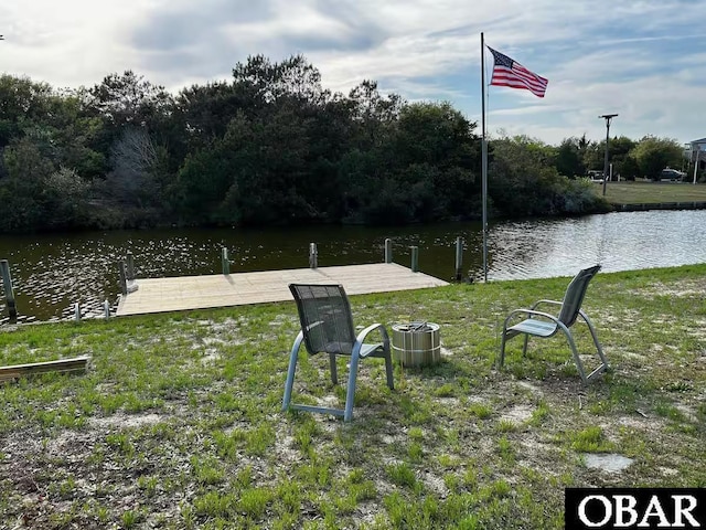 view of dock featuring a water view and a yard