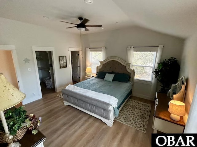 bedroom with baseboards, a ceiling fan, wood finished floors, and lofted ceiling