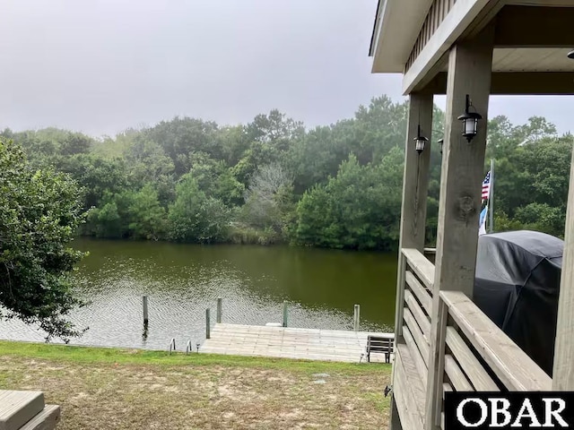 view of dock with a water view and a view of trees