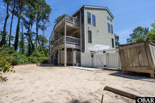 view of side of property with a balcony, a gate, and fence