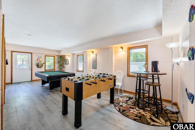 recreation room featuring a wealth of natural light, a textured ceiling, and wood finished floors