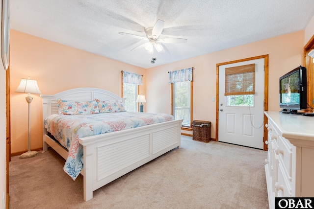 bedroom with a textured ceiling, ceiling fan, and light colored carpet