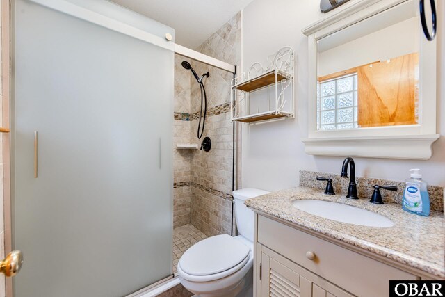 full bathroom with toilet, a stall shower, and vanity