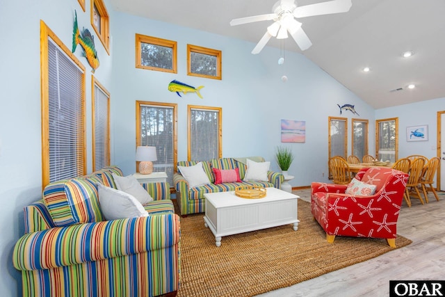 living room featuring baseboards, ceiling fan, light wood-type flooring, high vaulted ceiling, and recessed lighting