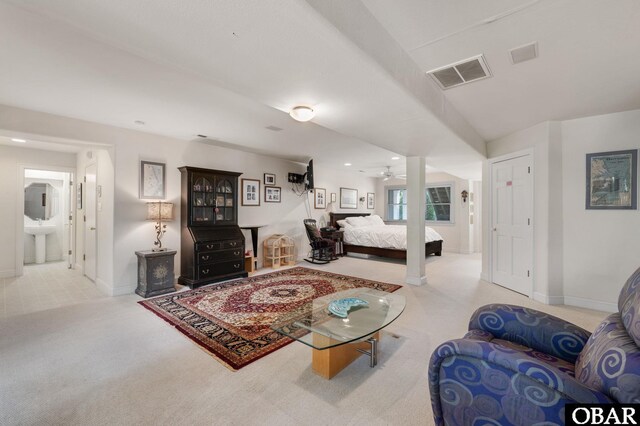 living area featuring light carpet, a ceiling fan, visible vents, and baseboards