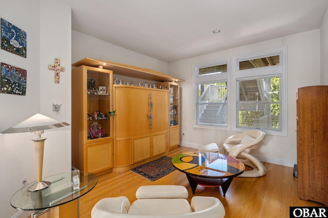 living area with light wood-style floors and baseboards