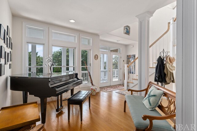 interior space with stairway, french doors, light wood-type flooring, ornate columns, and recessed lighting