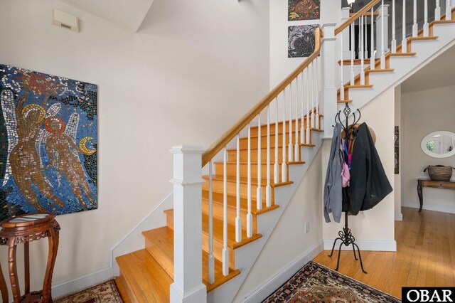 staircase with wood finished floors and baseboards