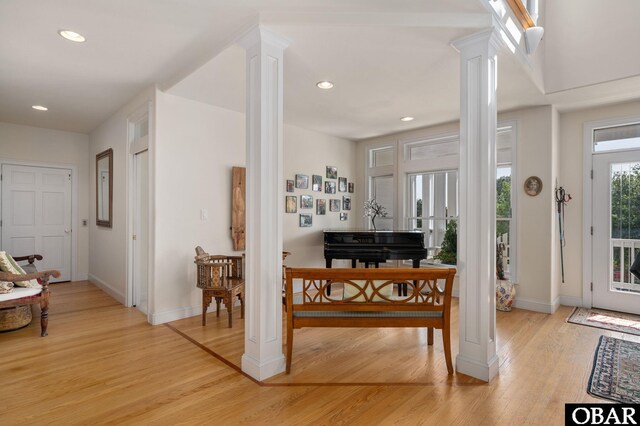 entryway featuring light wood-style floors, decorative columns, baseboards, and recessed lighting