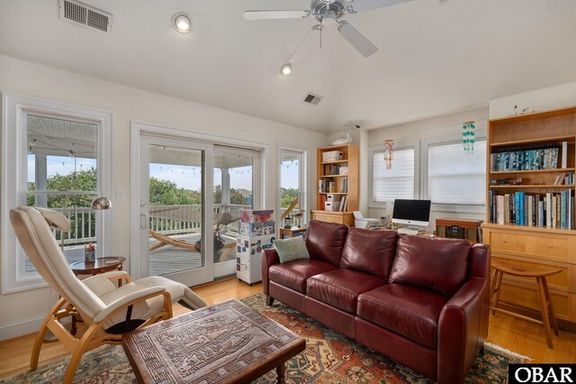 living room with ceiling fan, light wood-style flooring, lofted ceiling, and visible vents