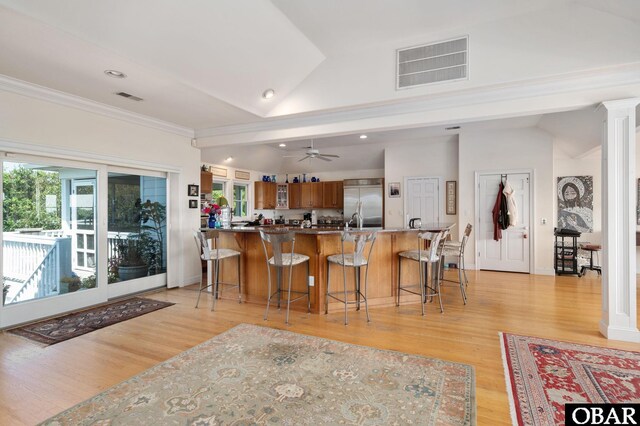 kitchen with brown cabinets, visible vents, stainless steel built in fridge, and decorative columns