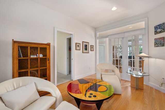 living area with recessed lighting, baseboards, and wood finished floors