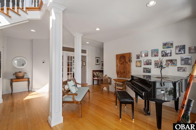 sitting room featuring baseboards, recessed lighting, decorative columns, and light wood-style floors