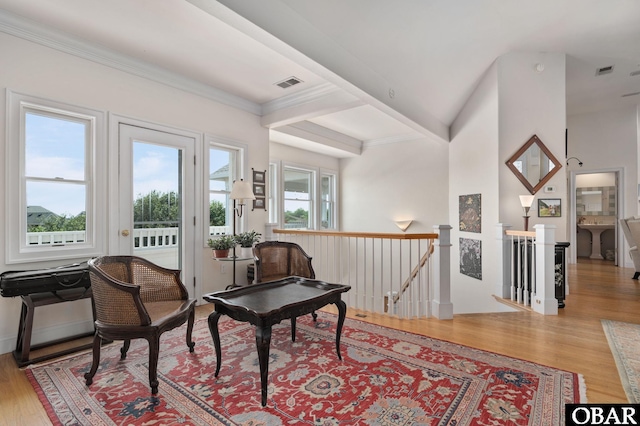 sitting room featuring light wood-type flooring, visible vents, plenty of natural light, and an upstairs landing