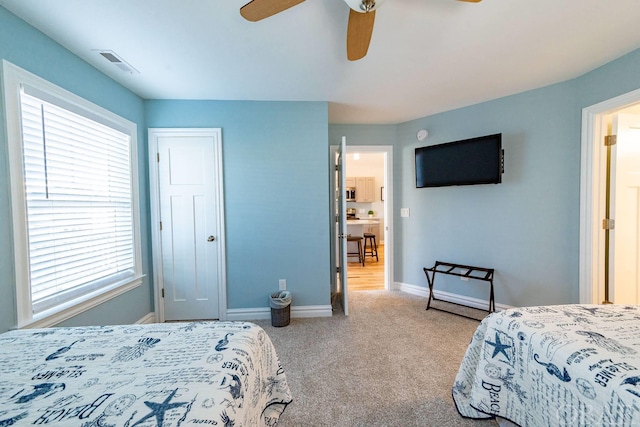 bedroom featuring baseboards, a ceiling fan, visible vents, and light colored carpet