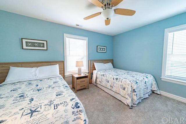 bedroom featuring visible vents, light carpet, baseboards, and multiple windows