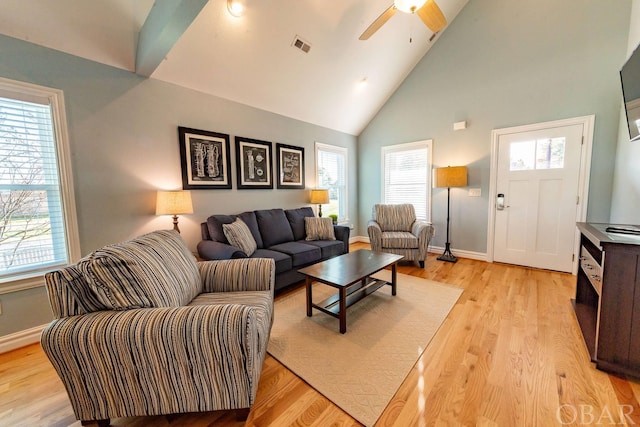 living area featuring light wood-style floors, baseboards, and a wealth of natural light