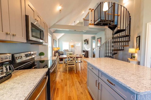 kitchen with light wood-style flooring, gray cabinetry, stainless steel appliances, open floor plan, and vaulted ceiling