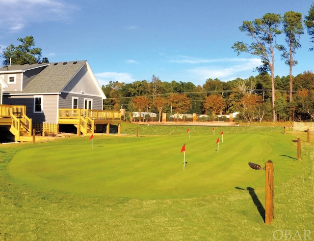 view of property's community featuring view of golf course, stairway, and a wooden deck