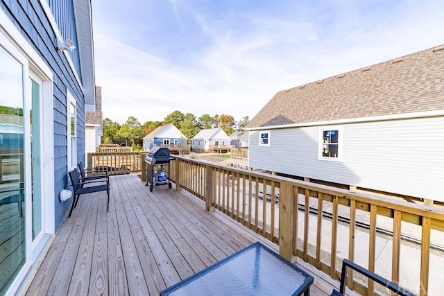 wooden deck featuring a grill and a residential view