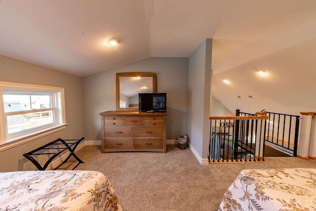 bedroom with vaulted ceiling, light carpet, and baseboards