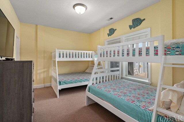 carpeted bedroom featuring baseboards and visible vents