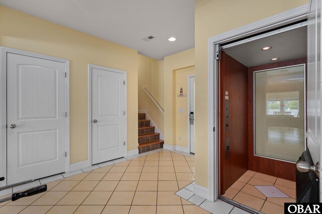 foyer entrance with light tile patterned floors, stairway, visible vents, and recessed lighting