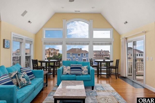 living area with a residential view, visible vents, and wood finished floors