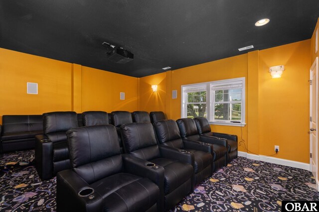 carpeted cinema featuring visible vents and baseboards