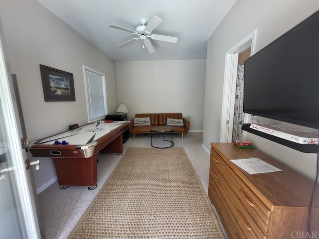 recreation room with ceiling fan and baseboards