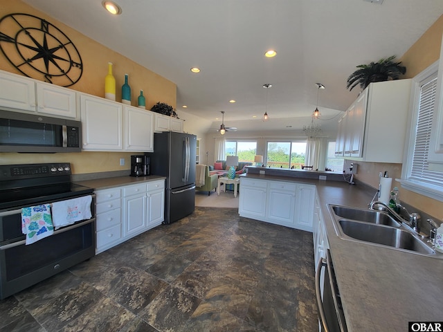 kitchen with a sink, a peninsula, open floor plan, stainless steel appliances, and white cabinets