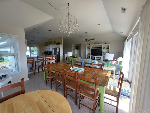 dining space with vaulted ceiling, a chandelier, visible vents, and light colored carpet