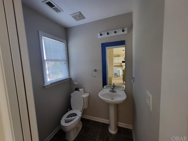 bathroom featuring tile patterned flooring, baseboards, visible vents, and toilet