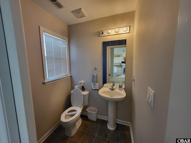 bathroom with toilet, visible vents, tile patterned flooring, and baseboards