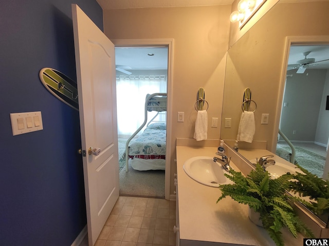 ensuite bathroom featuring a ceiling fan, baseboards, tile patterned flooring, ensuite bath, and vanity