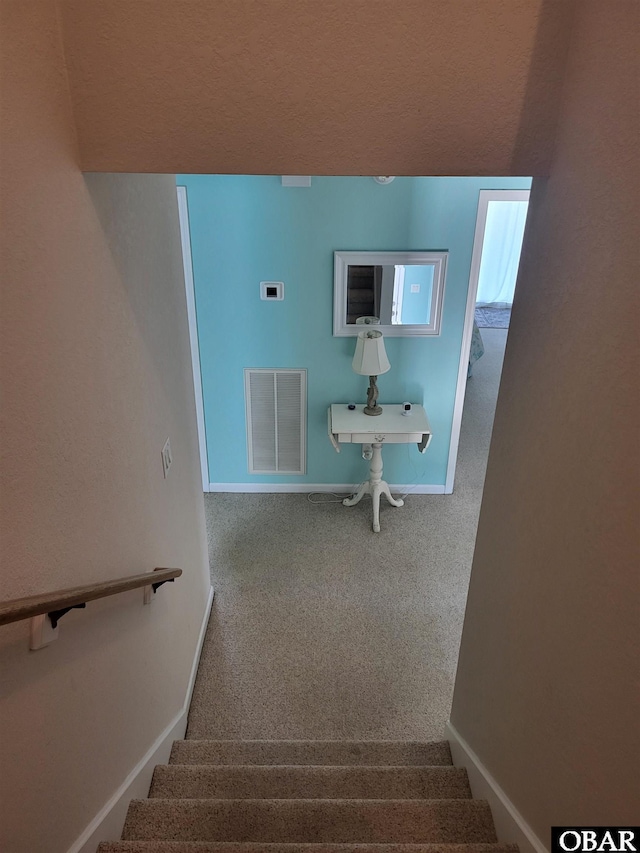 stairs with carpet flooring, baseboards, and visible vents