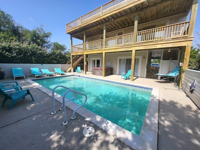 view of pool featuring a fenced in pool, fence, a jacuzzi, stairs, and a patio area