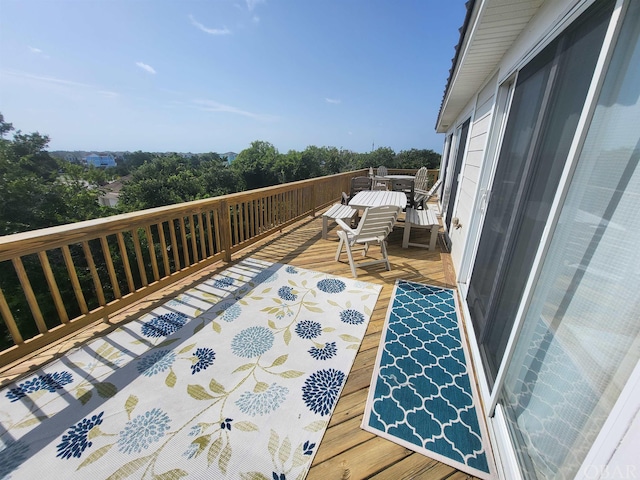 view of wooden balcony featuring outdoor dining area and a wooden deck