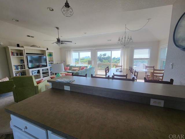 kitchen featuring dark countertops, open floor plan, white cabinetry, and a healthy amount of sunlight