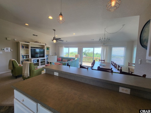 kitchen with ceiling fan with notable chandelier, recessed lighting, open floor plan, white cabinets, and baseboards