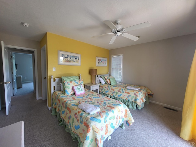 bedroom with a ceiling fan, dark colored carpet, visible vents, and baseboards