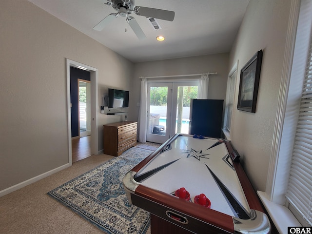 game room featuring light carpet, baseboards, and a ceiling fan