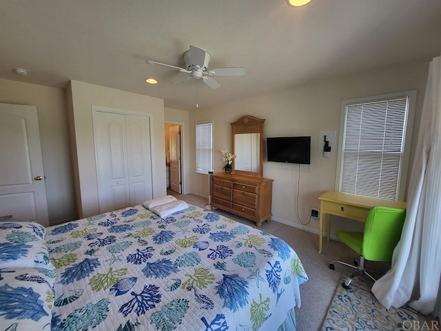 bedroom with a closet, light colored carpet, ceiling fan, and baseboards