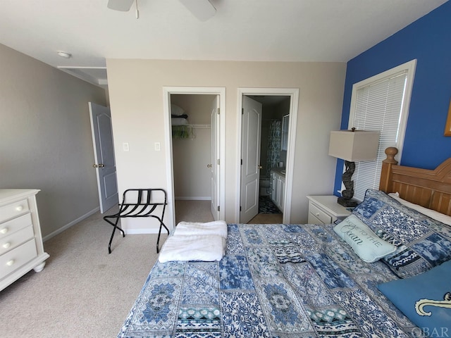 carpeted bedroom with connected bathroom, a ceiling fan, baseboards, a spacious closet, and a closet